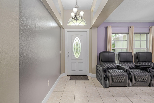 foyer with light tile patterned flooring, a chandelier, and baseboards