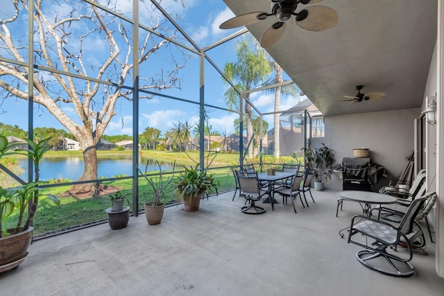 sunroom featuring a water view and ceiling fan