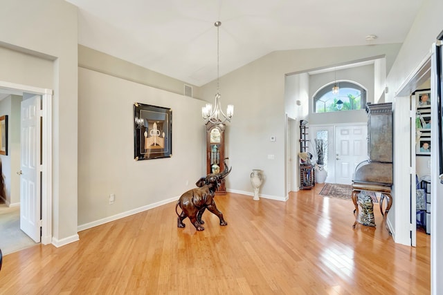 interior space with visible vents, baseboards, light wood-style flooring, a notable chandelier, and high vaulted ceiling