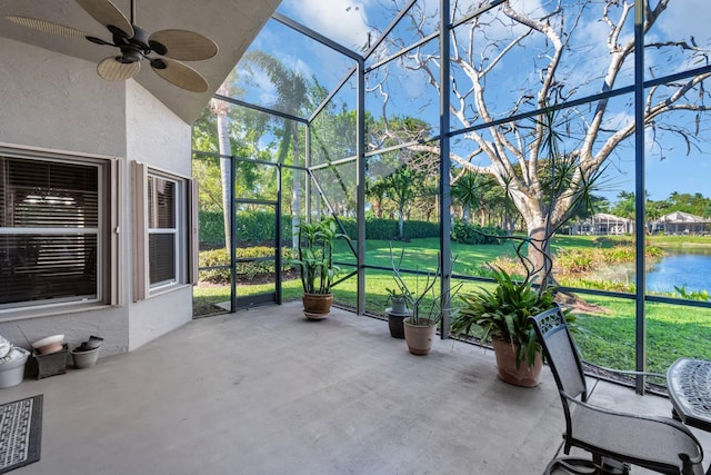 unfurnished sunroom featuring a water view, lofted ceiling, and a ceiling fan