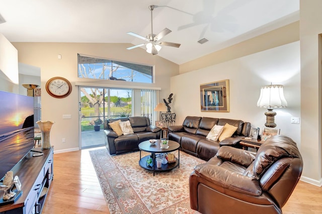 living room featuring baseboards, high vaulted ceiling, a ceiling fan, and light wood-style floors