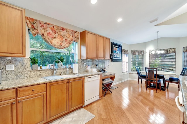 kitchen featuring visible vents, a sink, white dishwasher, light wood finished floors, and lofted ceiling