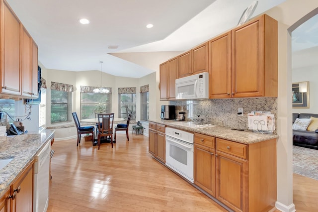 kitchen with decorative backsplash, white appliances, light wood-style floors, and light stone countertops