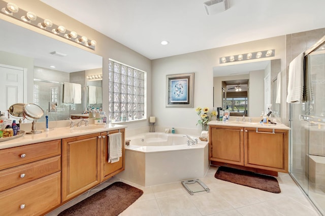 full bath with visible vents, plenty of natural light, two vanities, a stall shower, and tile patterned flooring