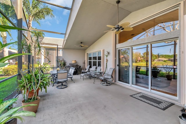 unfurnished sunroom featuring a ceiling fan and vaulted ceiling