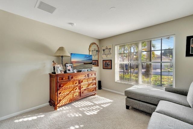 living area featuring visible vents, baseboards, and carpet