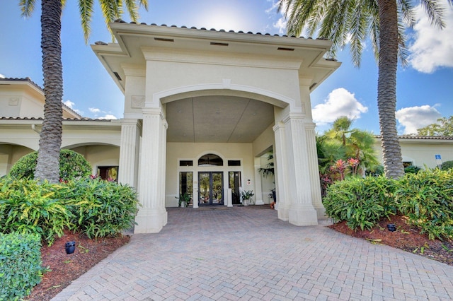 entrance to property featuring french doors and stucco siding