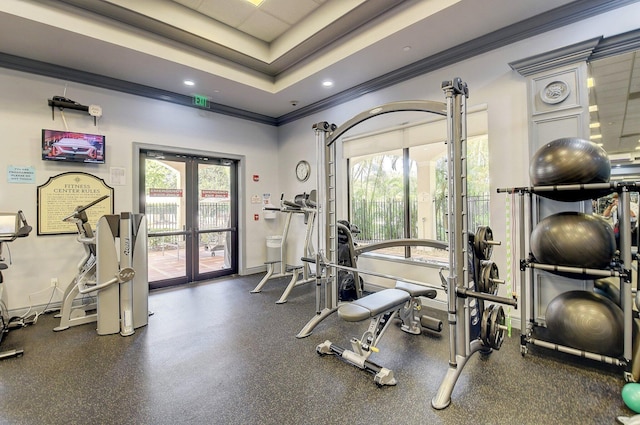 workout area featuring crown molding, french doors, baseboards, and a raised ceiling