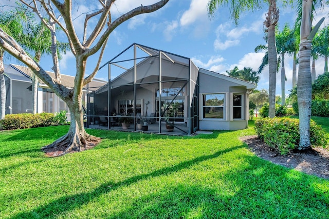 back of property with a lanai, a yard, a patio area, and stucco siding