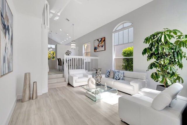 living area with baseboards and high vaulted ceiling