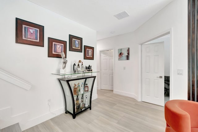 hall featuring baseboards and visible vents