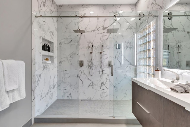 full bath with a marble finish shower and vanity