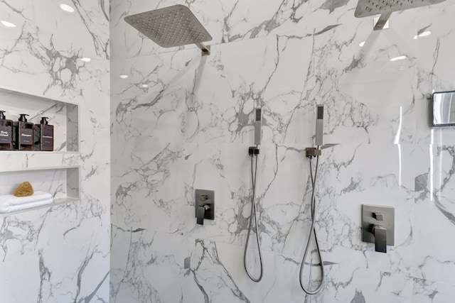 full bath featuring a marble finish shower and stone wall