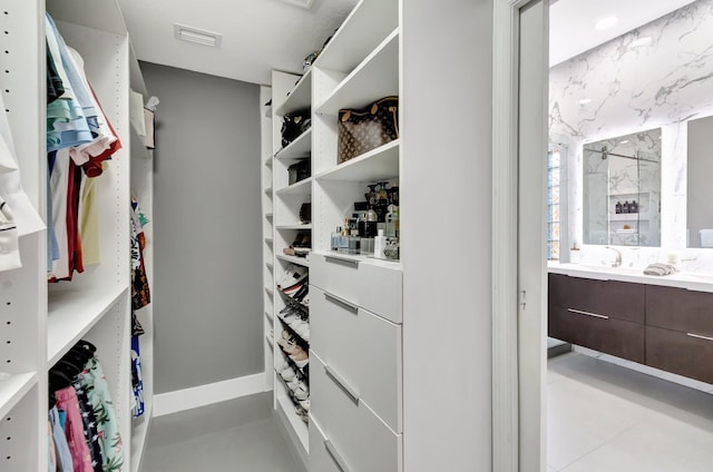 walk in closet with visible vents and a sink