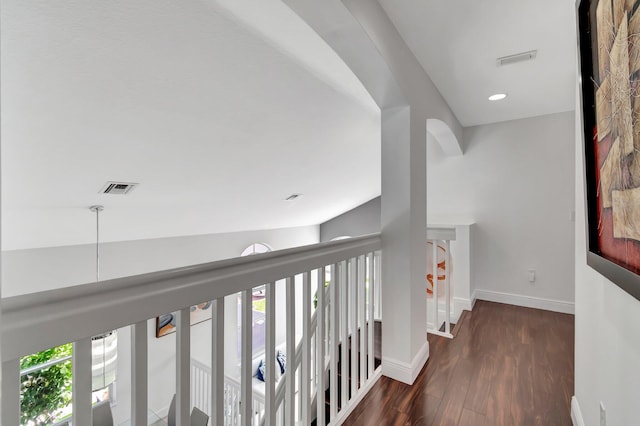 hall featuring baseboards, plenty of natural light, visible vents, and wood finished floors