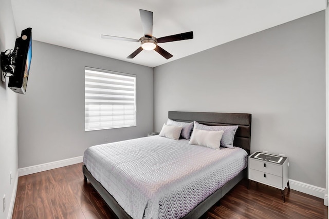 bedroom featuring a ceiling fan, baseboards, and wood finished floors