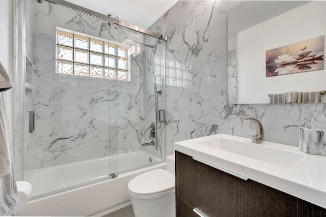 bathroom with vanity, shower / bath combination with glass door, tile walls, toilet, and tasteful backsplash