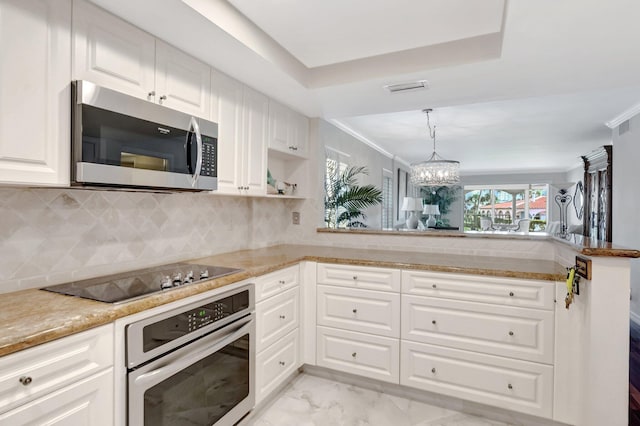 kitchen with stainless steel microwave, wall oven, a chandelier, marble finish floor, and black electric cooktop