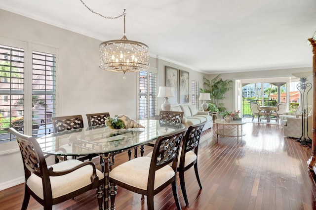 dining space featuring a notable chandelier, crown molding, baseboards, and wood-type flooring