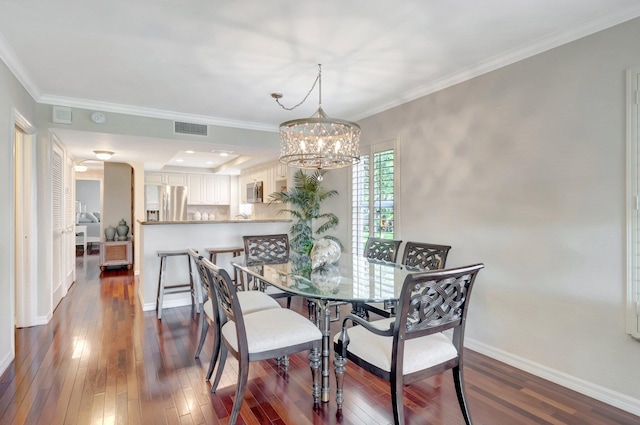 dining room with an inviting chandelier, dark wood-type flooring, crown molding, and visible vents