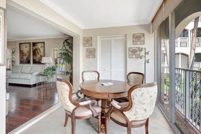 dining space with light tile patterned floors, arched walkways, and ornamental molding