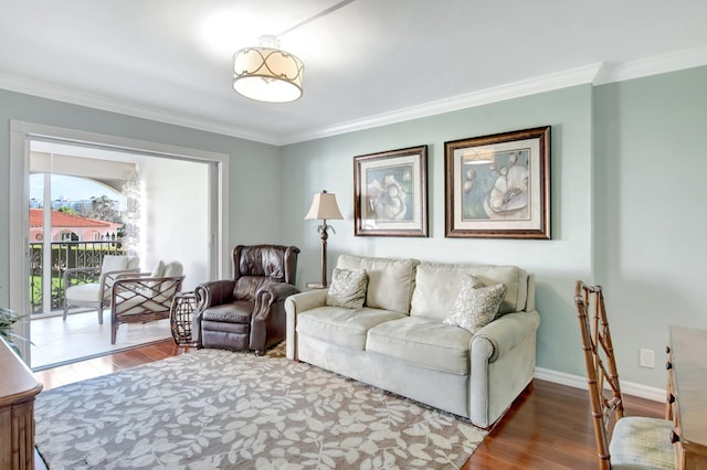 living area featuring crown molding, wood finished floors, and baseboards