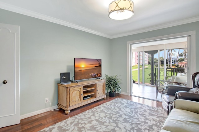 living area with wood finished floors, baseboards, and ornamental molding