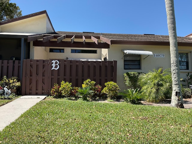 view of property exterior featuring fence, a lawn, and stucco siding