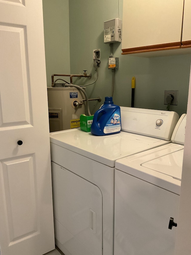 laundry room featuring cabinet space, independent washer and dryer, and water heater