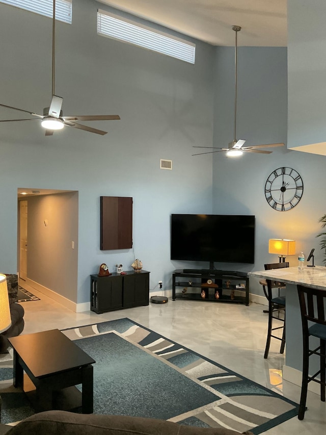 living room featuring a wealth of natural light, visible vents, baseboards, and a high ceiling