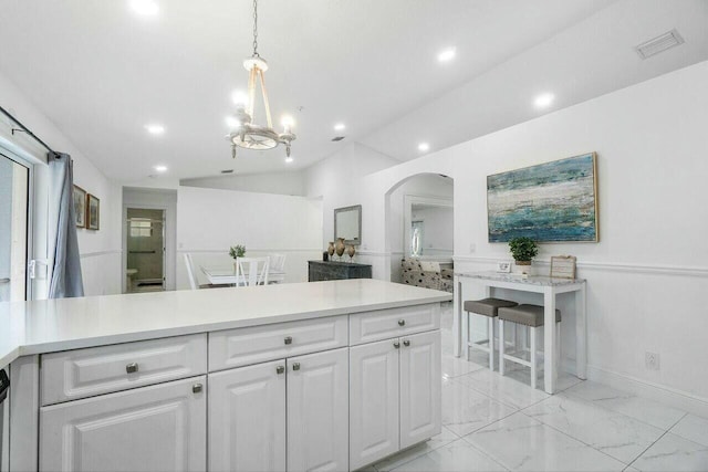 kitchen with visible vents, marble finish floor, arched walkways, white cabinets, and light countertops