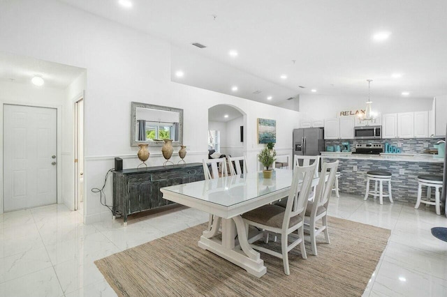 dining space featuring arched walkways, visible vents, marble finish floor, and recessed lighting