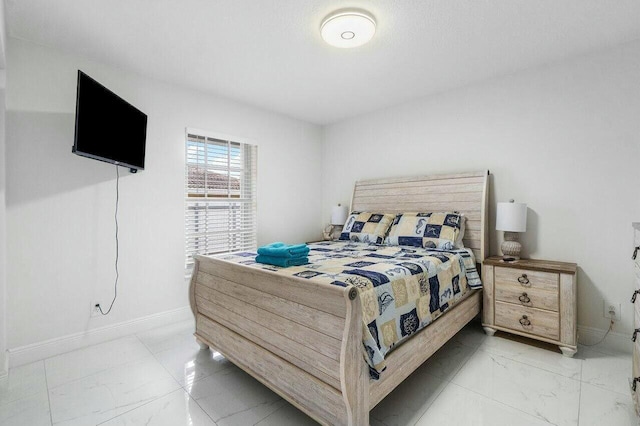 bedroom with baseboards and marble finish floor