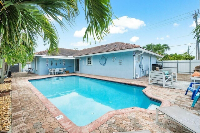 view of pool with a patio area, a fenced in pool, and fence