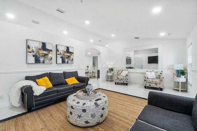 living room featuring recessed lighting, visible vents, arched walkways, and lofted ceiling