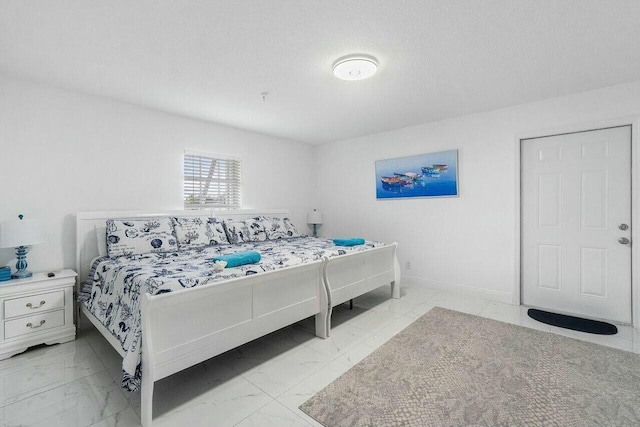 bedroom with baseboards, a textured ceiling, and marble finish floor