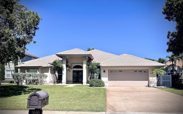 view of front of home with a front lawn, french doors, driveway, and stucco siding