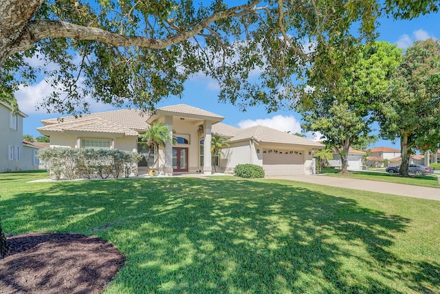 view of front of property featuring a front yard, driveway, french doors, a garage, and a tile roof