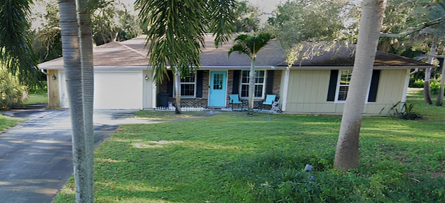 single story home featuring driveway, a front yard, and a garage