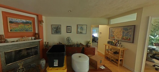 sitting room featuring a glass covered fireplace and baseboards