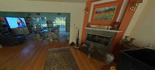 living area with a fireplace and wood finished floors