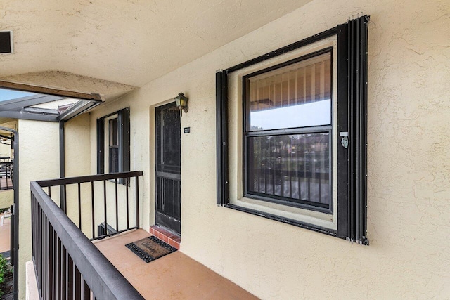 doorway to property featuring a balcony and stucco siding