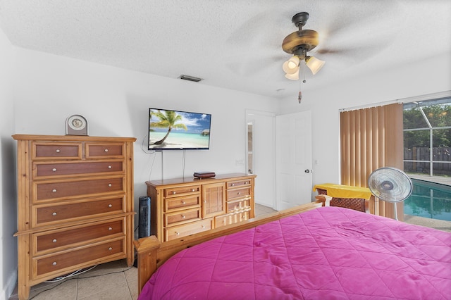 bedroom with light tile patterned floors, a ceiling fan, visible vents, a textured ceiling, and access to outside