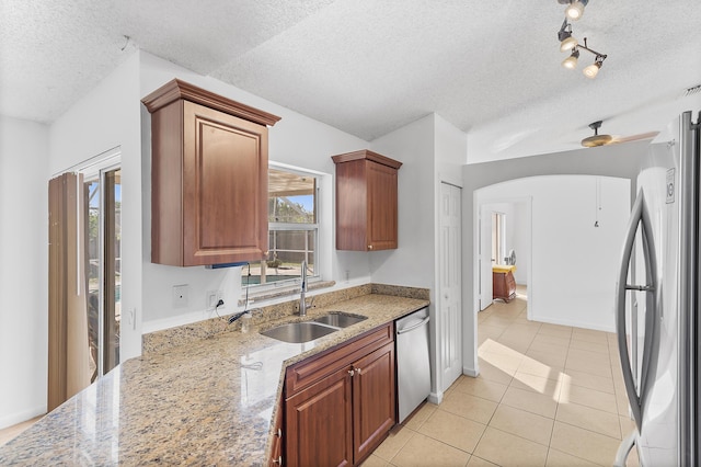 kitchen featuring a sink, plenty of natural light, arched walkways, and stainless steel appliances