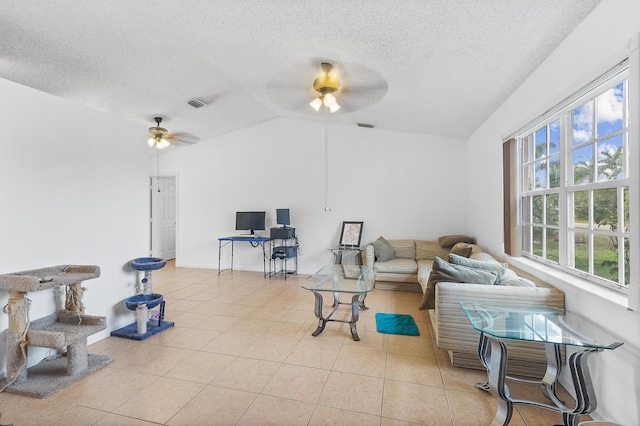 living area with a ceiling fan, visible vents, light tile patterned flooring, vaulted ceiling, and a textured ceiling