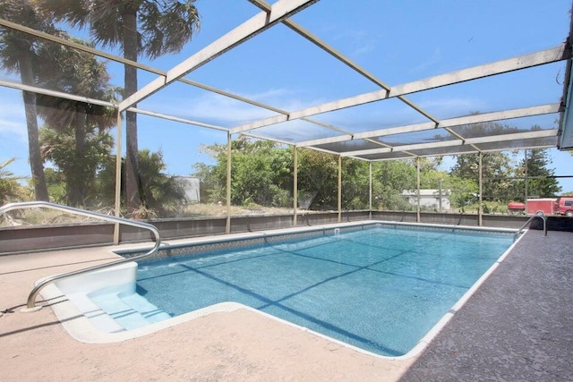 pool featuring glass enclosure and a patio