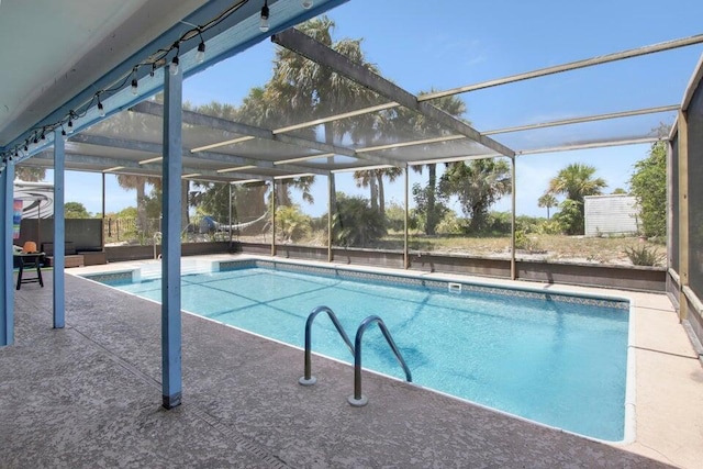 pool with glass enclosure and a patio