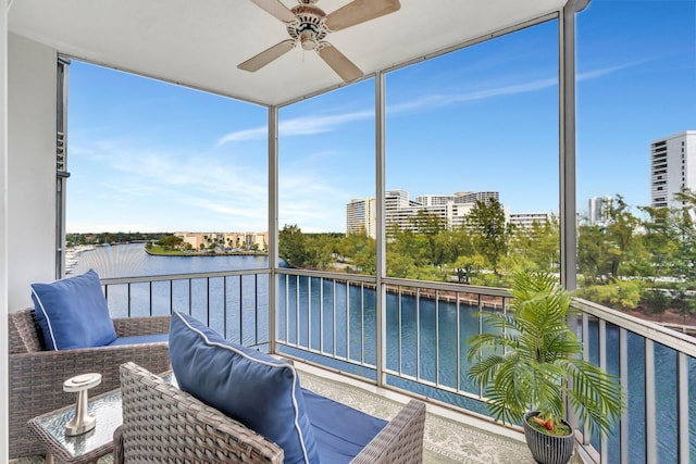 sunroom featuring a water view, a city view, and ceiling fan