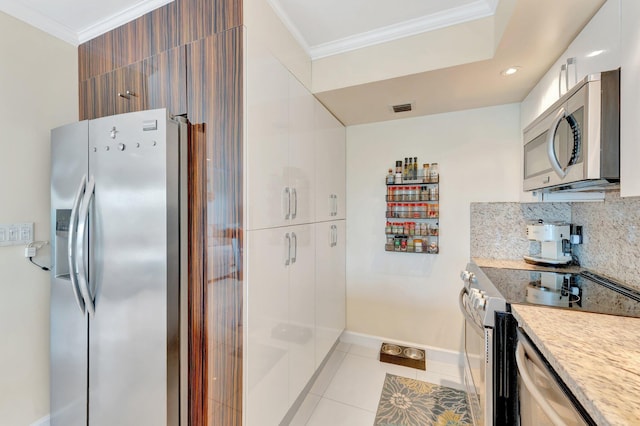 kitchen with light tile patterned floors, backsplash, stainless steel appliances, and ornamental molding