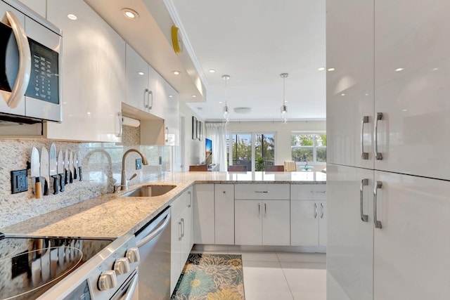 kitchen featuring a sink, stainless steel appliances, white cabinetry, modern cabinets, and backsplash